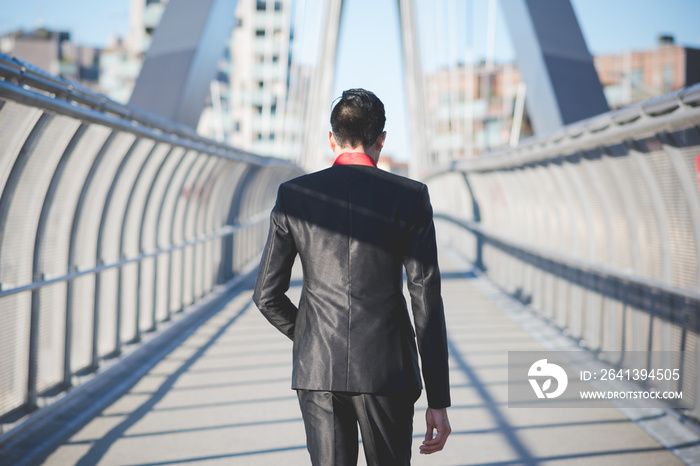 Young businessman crossing bridge