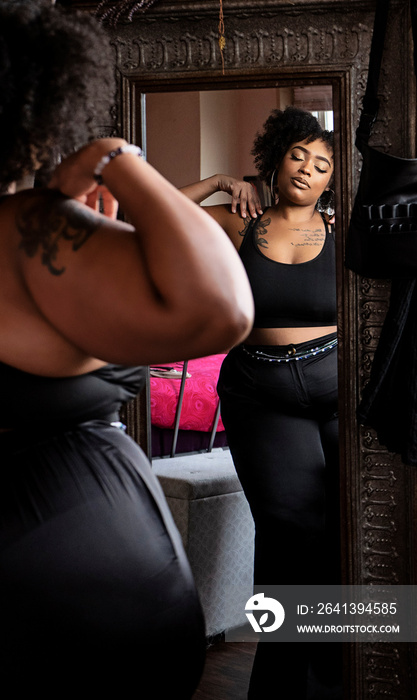 Black woman looking in mirror admiring herself