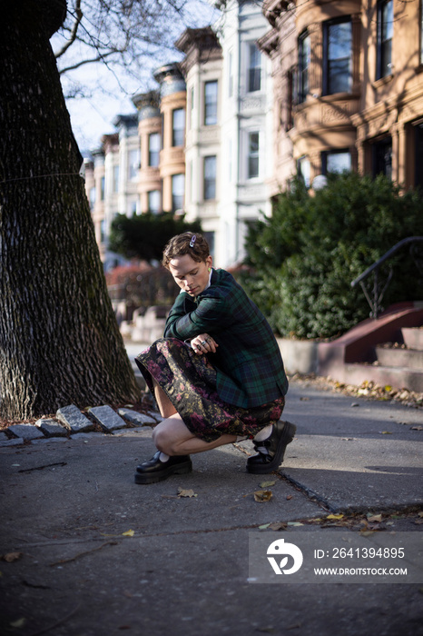 non-binary caucasian person with short hair posing on Brooklyn sidewalk