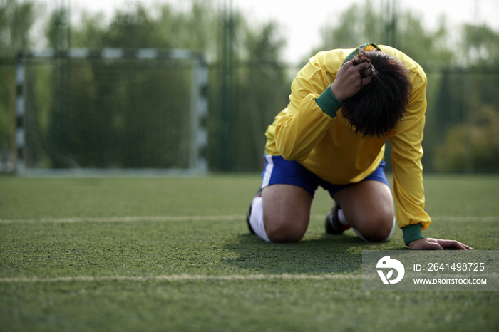 足球运动员趴在草地上