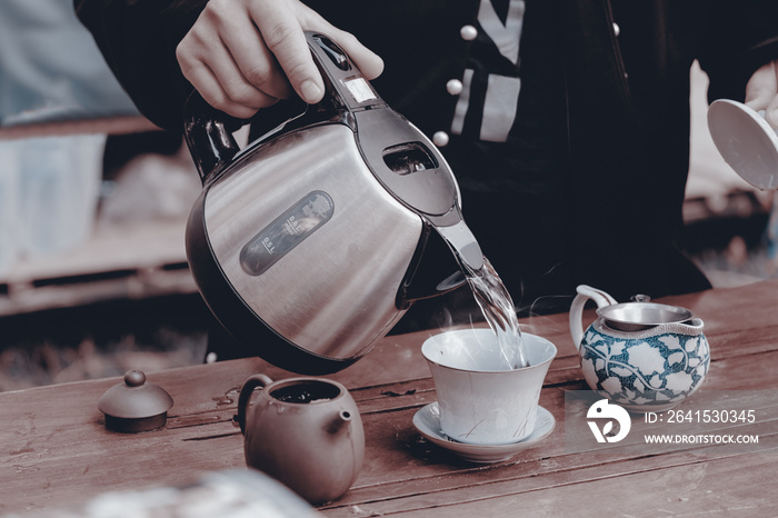 Tea making / View of young man making tea in the garden. Vintage style. Movement.