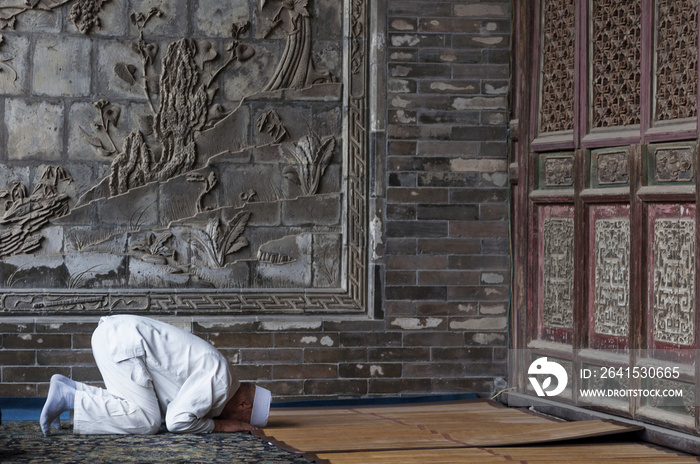 One man praying at the XiAn Great Mosque in the city of XiAn in China, Asia.