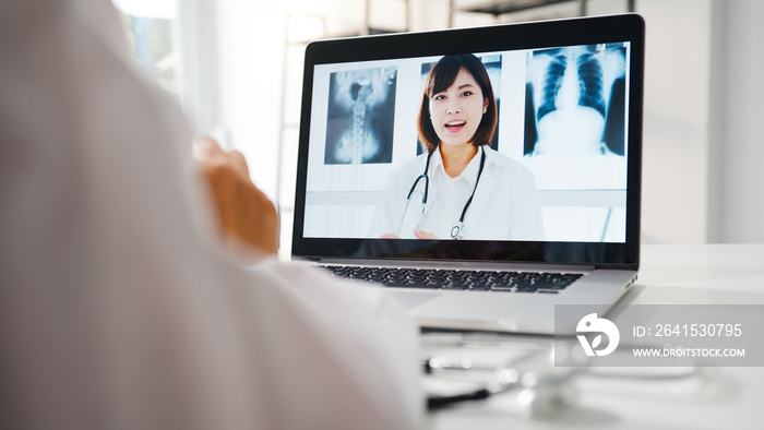 身穿白色医疗服的亚洲年轻女医生使用笔记本电脑与se进行视频通话