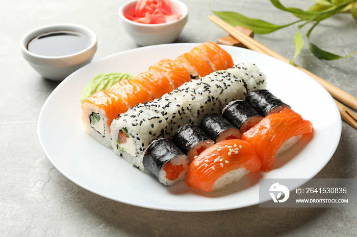 Plate with sushi rolls on gray background. Japanese food