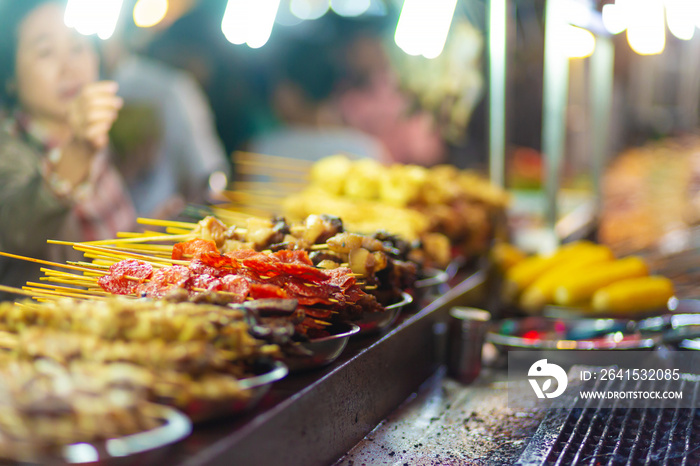 Traditional fried chinese food on sticks at street vendor market