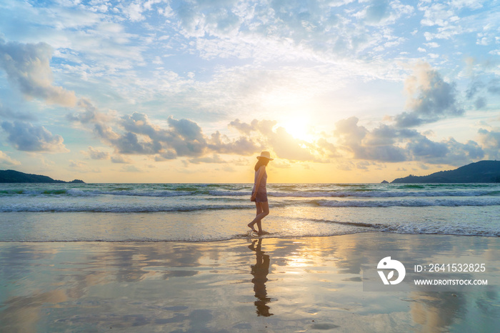 Happy Asian woman relaxing and enjoying at the beach during travel holidays vacation outdoors at oce