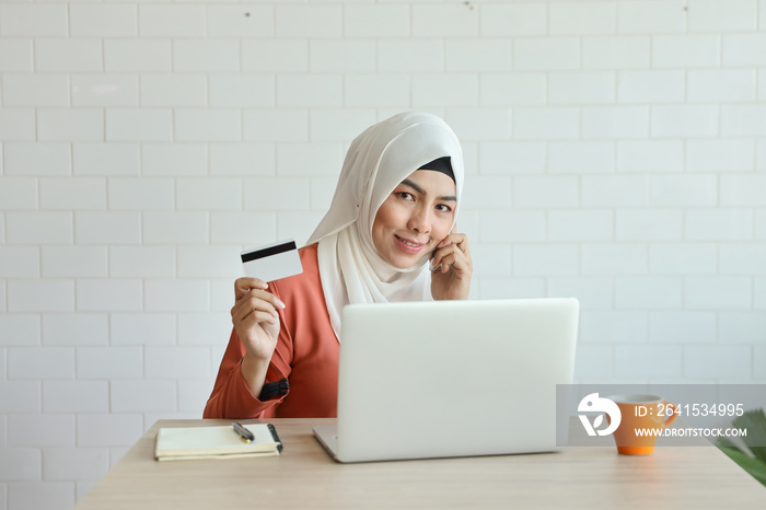 young muslim businesswoman shopping and online payment by using notebook, cell phone and credit card