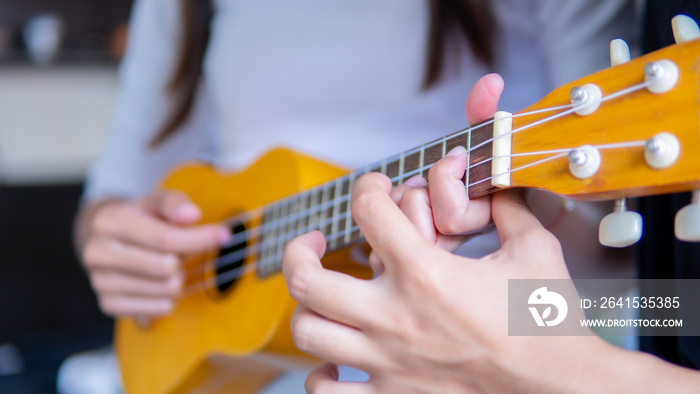 Close up hand playing ukulele