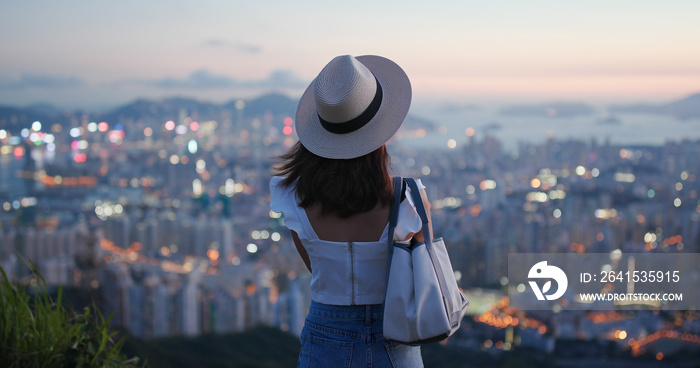 女人在日落时欣赏美丽的城市景观