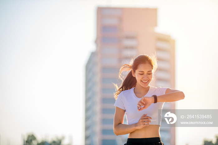 Asian women is watching the sport watch or smart watch for jogging on city