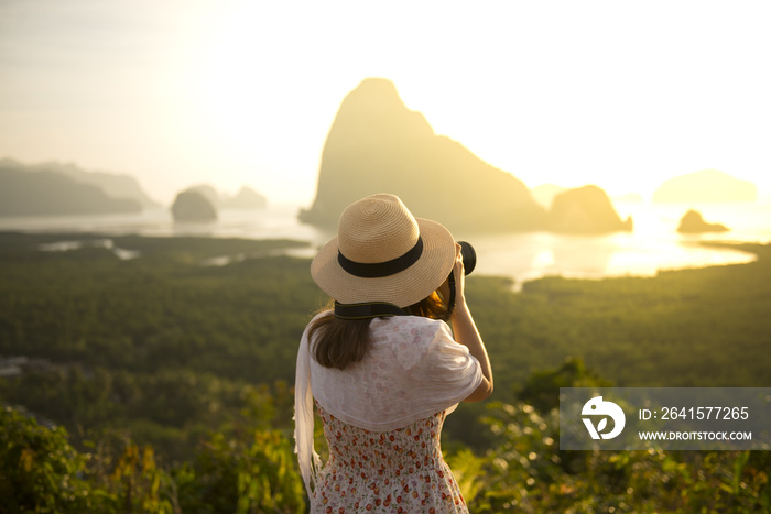 Woman tourist is taking photograph at Samed Nang She point of view in Phang Nga, Thailand during sum