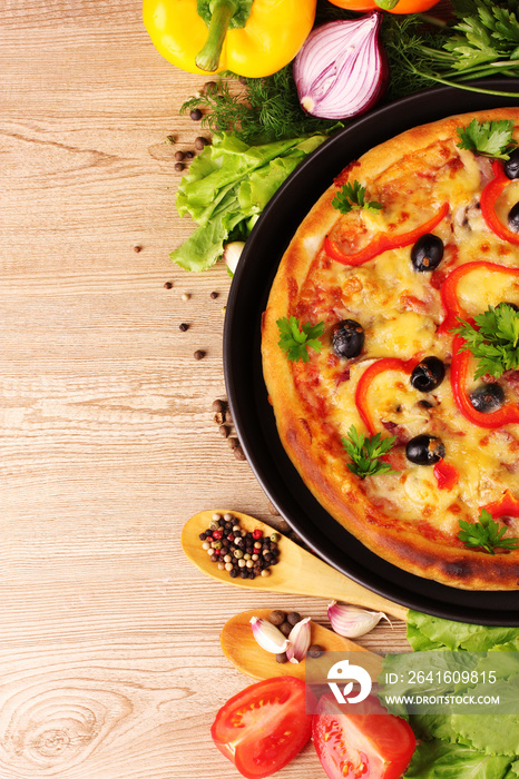 美味的披萨放在盘子里，蔬菜放在木制背景上