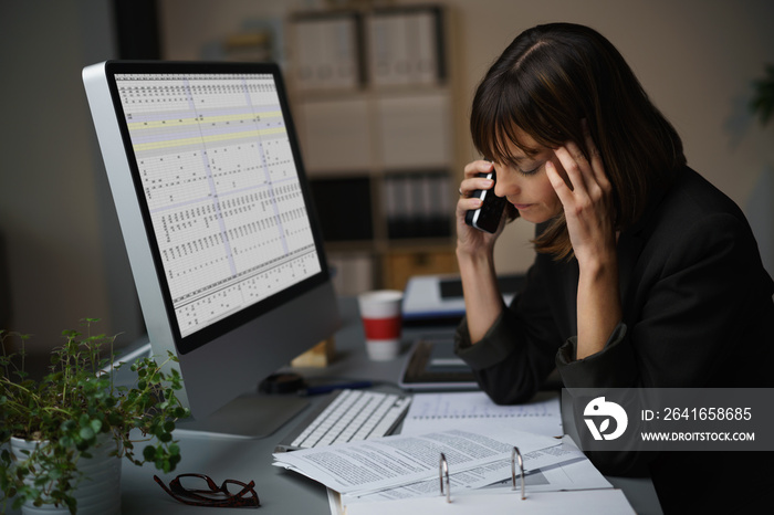 frau arbeitet im büro bis spät am abend und telefoniert