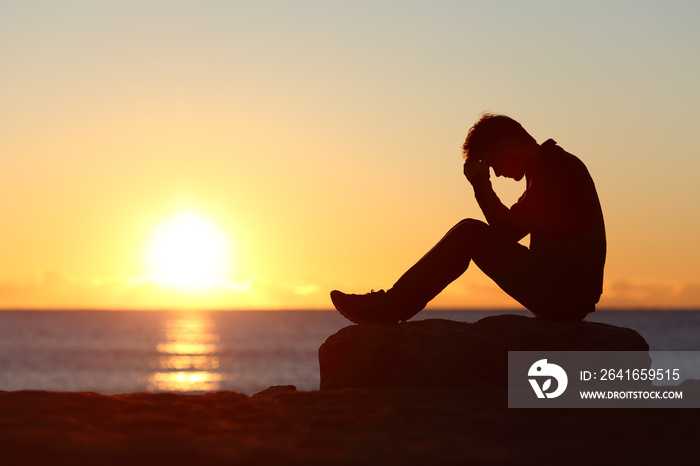 Sad man silhouette worried on the beach