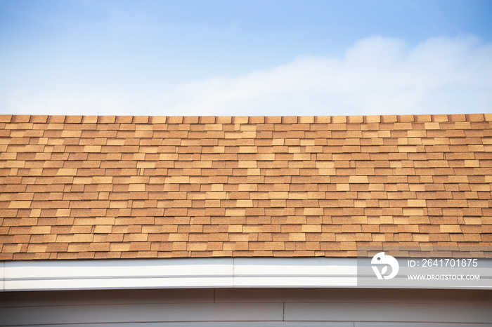 brown roof shingle and blue sky. asphalt tiles on the roof