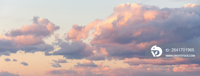 Beautiful fluffy clouds on sunny day at golden hour painted with sun