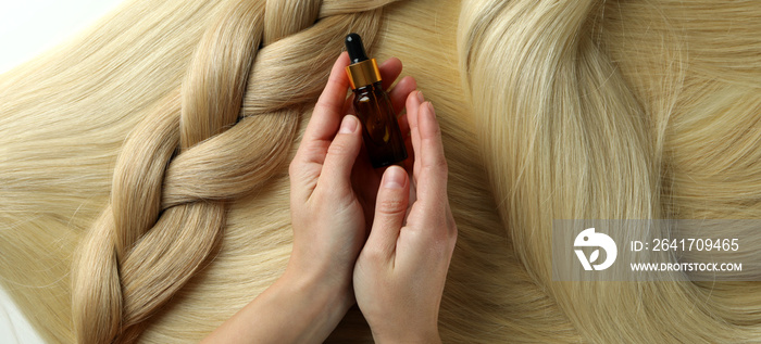 Concept of hair care with female hands hold bottle of cosmetic