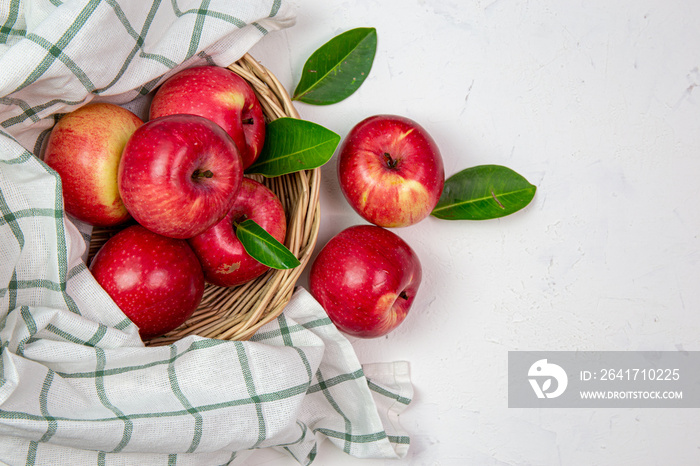 Happy red apples in a sweet basket on a white table. Art style, the top view has space for your mess