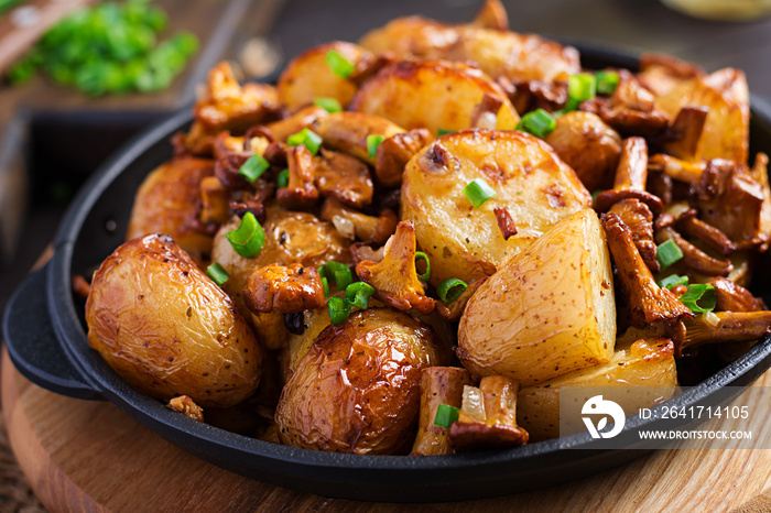 Baked potatoes with garlic, herbs and fried chanterelles in a cast iron skillet.