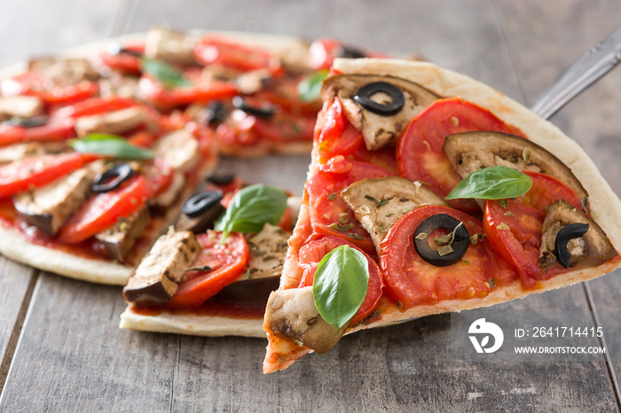 Showing vegetarian pizza slice with eggplant, tomato, black olives, oregano and basil