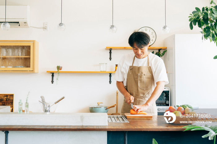 キッチンに立つ男性（野菜を切る）