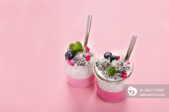 Layered chia puding with pink filling on pink background.