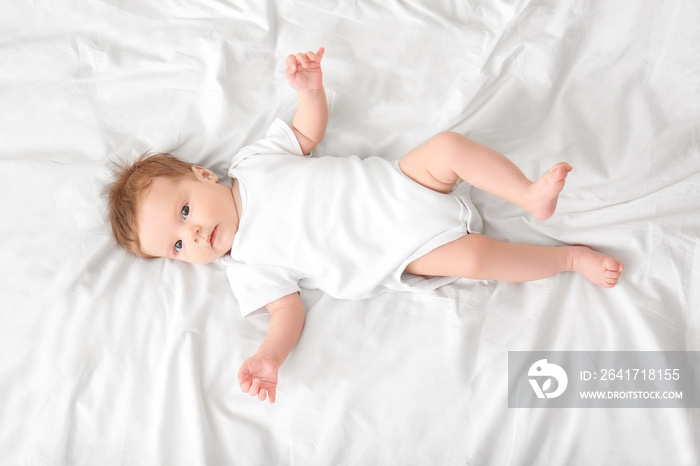 Cute little baby lying on bed at home