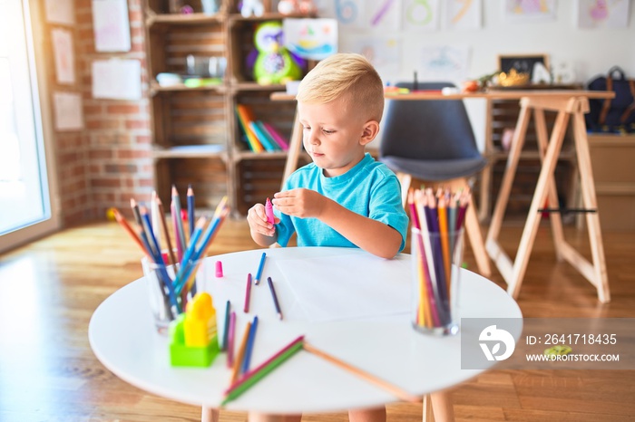 年轻的高加索孩子在幼儿园玩玩具。学龄前男孩在游戏室玩得很开心。