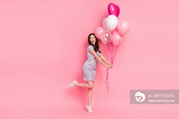 Photo of funny funky lady dressed dotted dress holding balloons walking isolated pink color backgrou