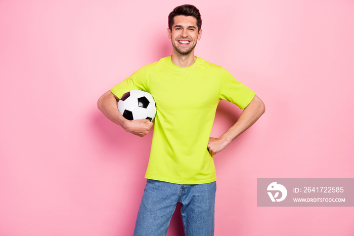 照片肖像微笑的男子穿着明亮的t恤，保持足球隔离，淡粉色bac