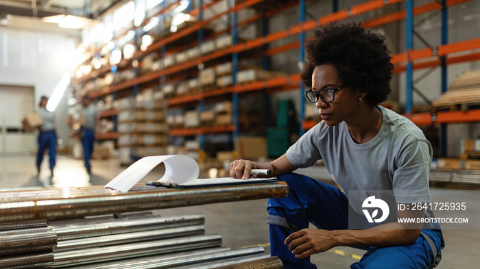 African American warehouse worker going through her check list.