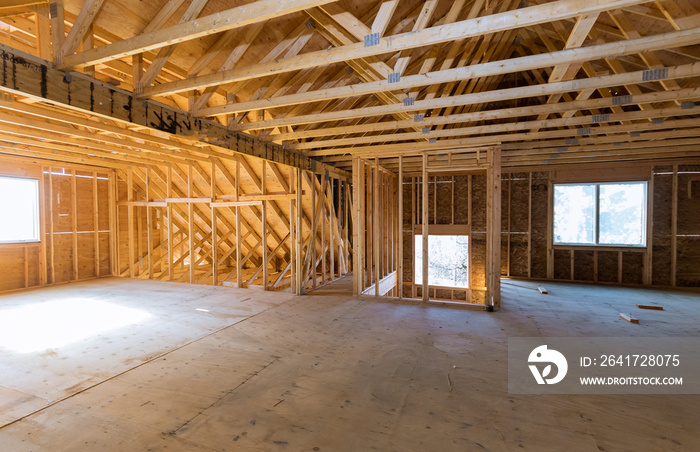 Beam built home under construction with wooden truss, post and beam framework frame house