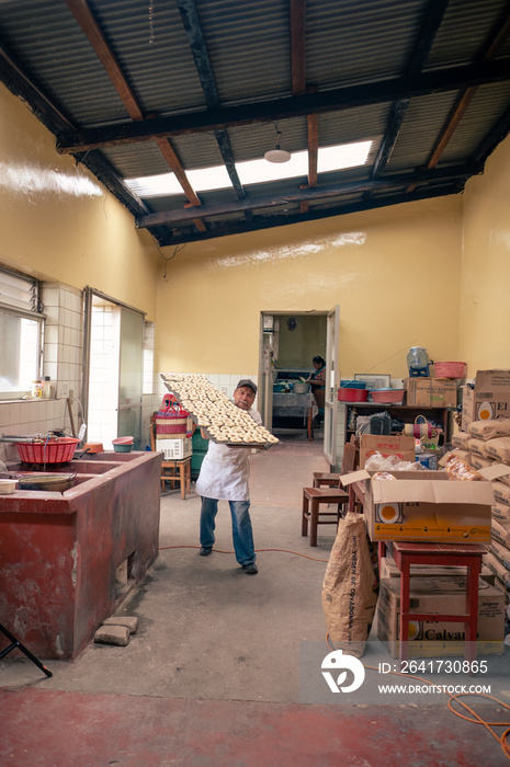 Hombre trabajando en su panadería. Panadero latino haciendo pan artesanal.