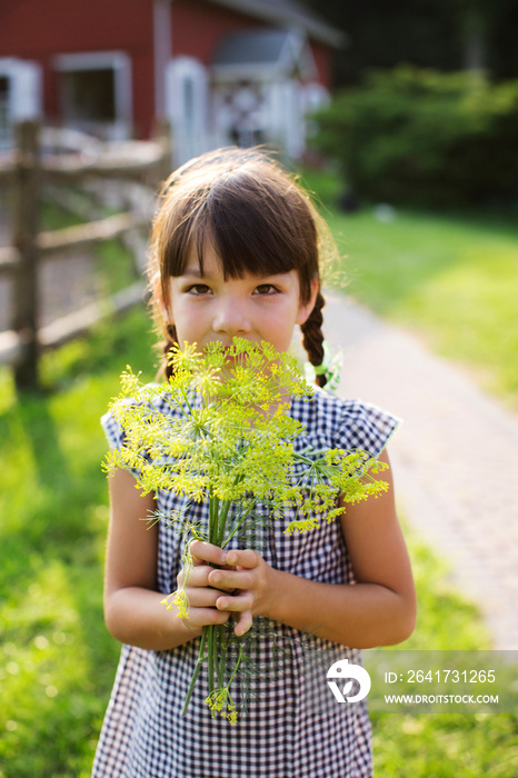 Portrait of girl (6-7) holding wildflowers