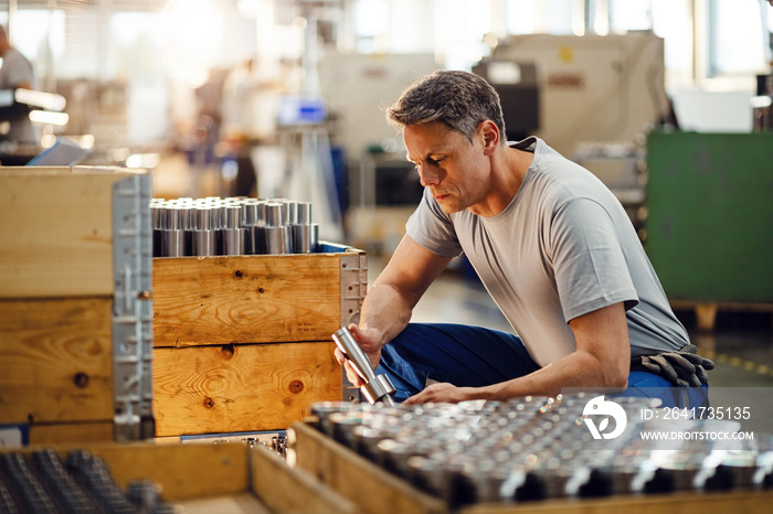 Steel worker examining finished products in a factory.