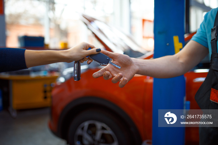 Female driver gives keys to worker in uniform