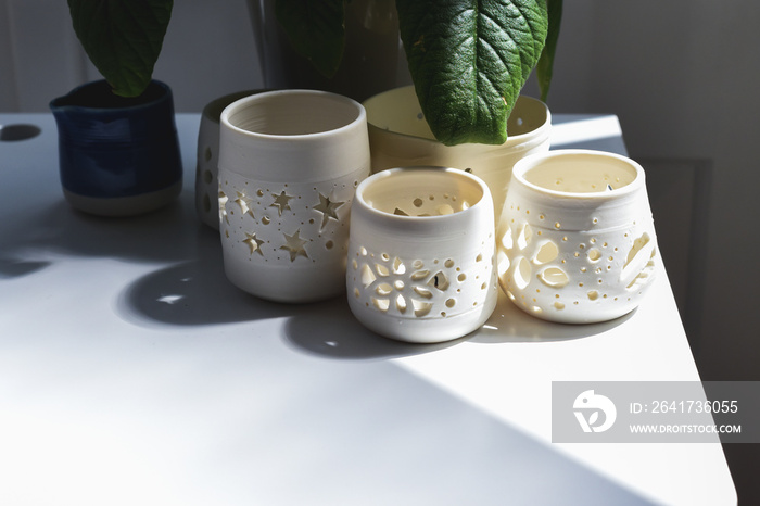 Group of hand made pottery vases and ceramic decorative bowls in room interior