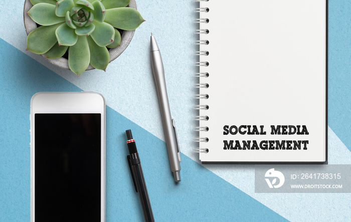 notebook with message  social media management  on paperbackground with smartphone and pen