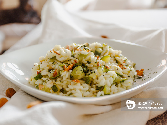 Vegan zucchini risotto with almonds in a white ceramic dish-1