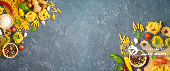 Italian pasta, tomatoes, basil herbs and spices over dark background. Italian cuisine concept