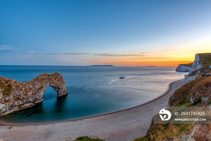 The natural arch Durdle Door at the Jurassic Coast in England after sunset