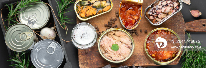 Various canned fish and seafood in aluminum cans. On dark gray background.