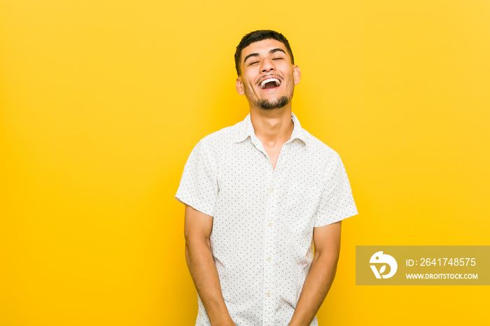 Young hispanic man relaxed and happy laughing, neck stretched showing teeth.