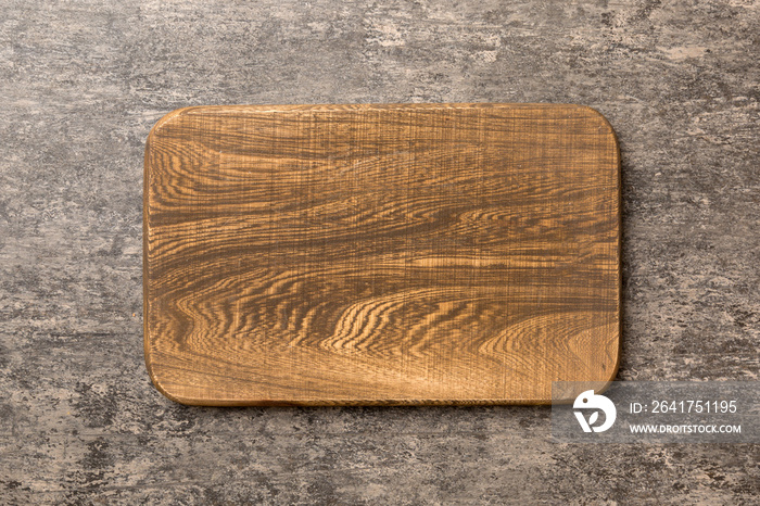 Top view of wooden cutting board on cement background. Empty space for your design