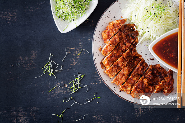 Japanese cuisine. Deep-fried pork chop, or Japanese chop with cabbage and tonkatsu sauce. Top view