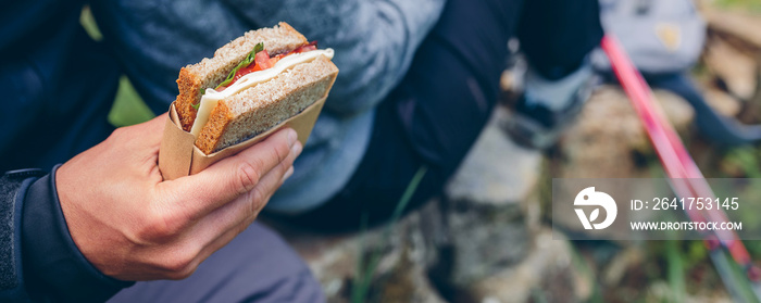 Detail of a sandwich that a couple is going to eat making a break to do trekking