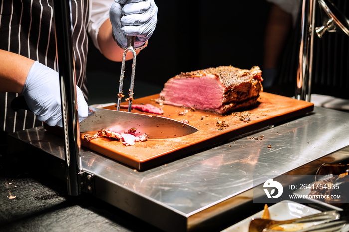 chef cutting meat in restaurant