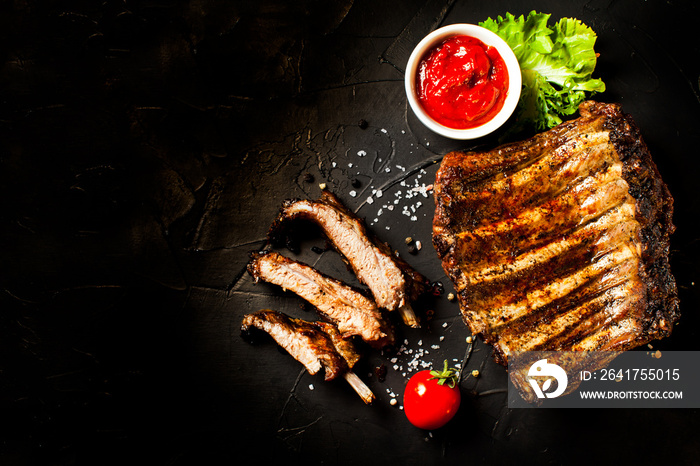 Grilled sliced barbecue pork ribs on the black background