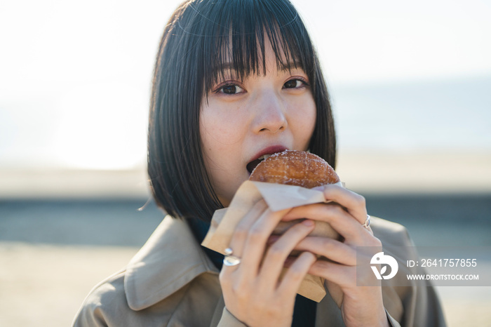 ドーナツを食べる女性