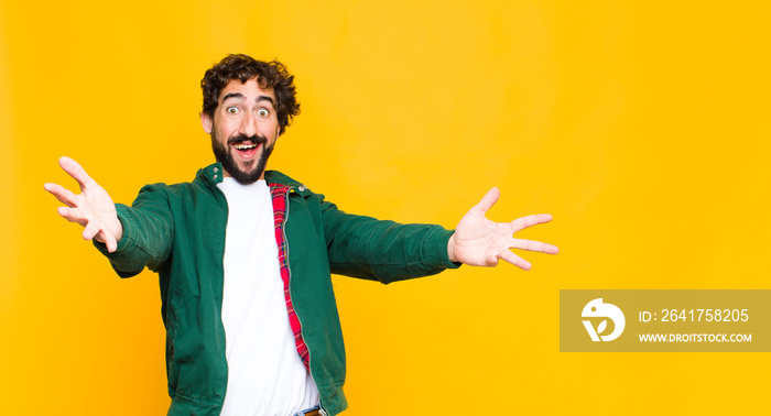 young crazy bearded man smiling cheerfully giving a warm, friendly, loving welcome hug, feeling happ